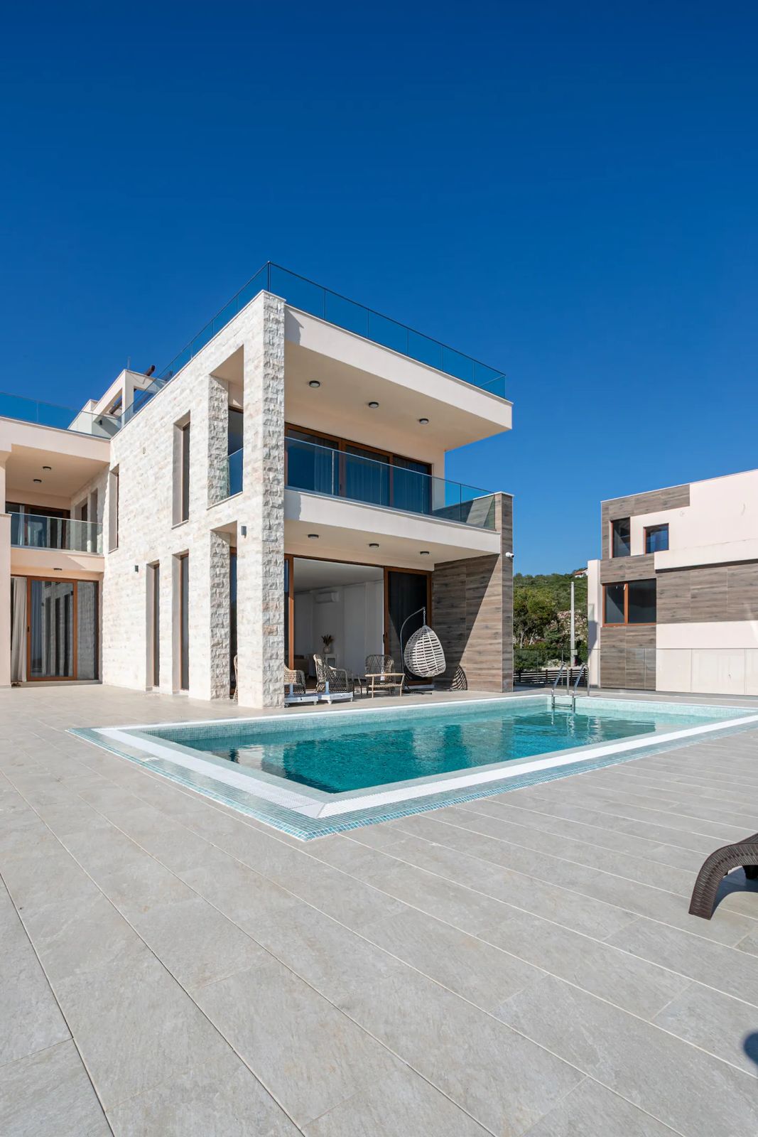 Luxury villa exterior with pool at dusk